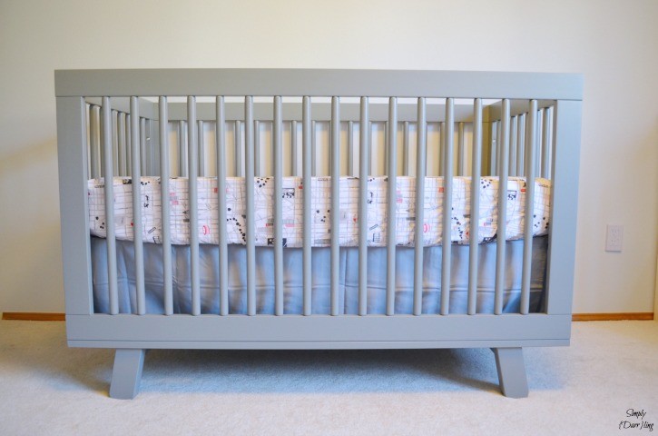 A grey and white nursery featuring the babyletto hudson crib in grey. 