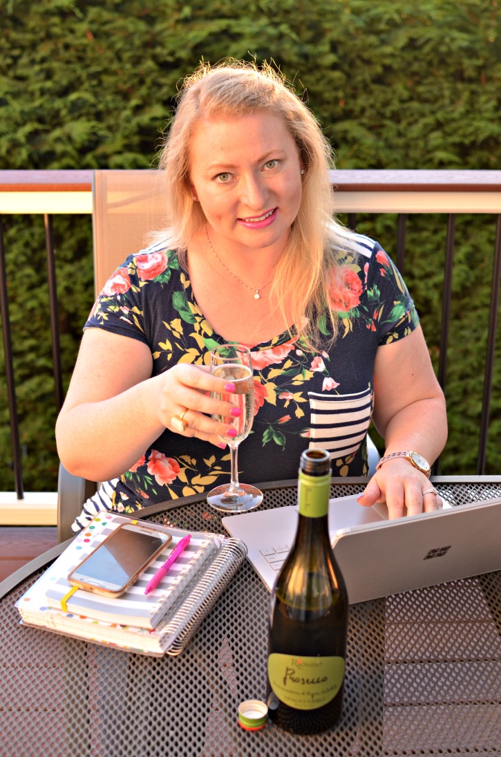 Woman at computer with prosecco and laptop
