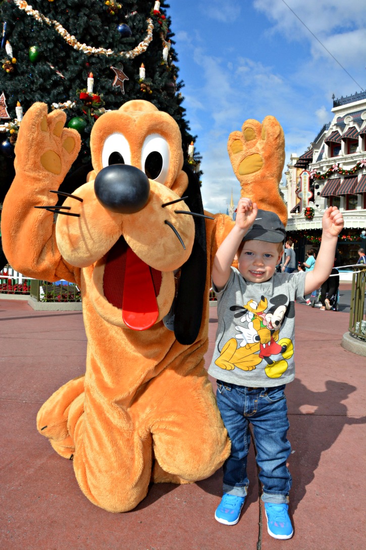 Toddler with Pluto at Walt Disney World doing Touchdown Pose