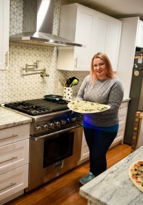 Woman holding Papa Murphy Pizza in Kitchen