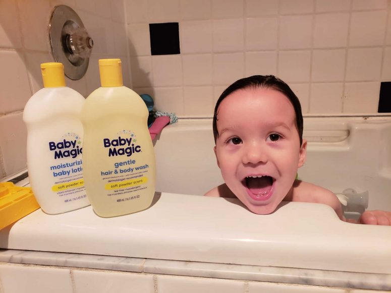 Toddler in bath with baby magic bottles