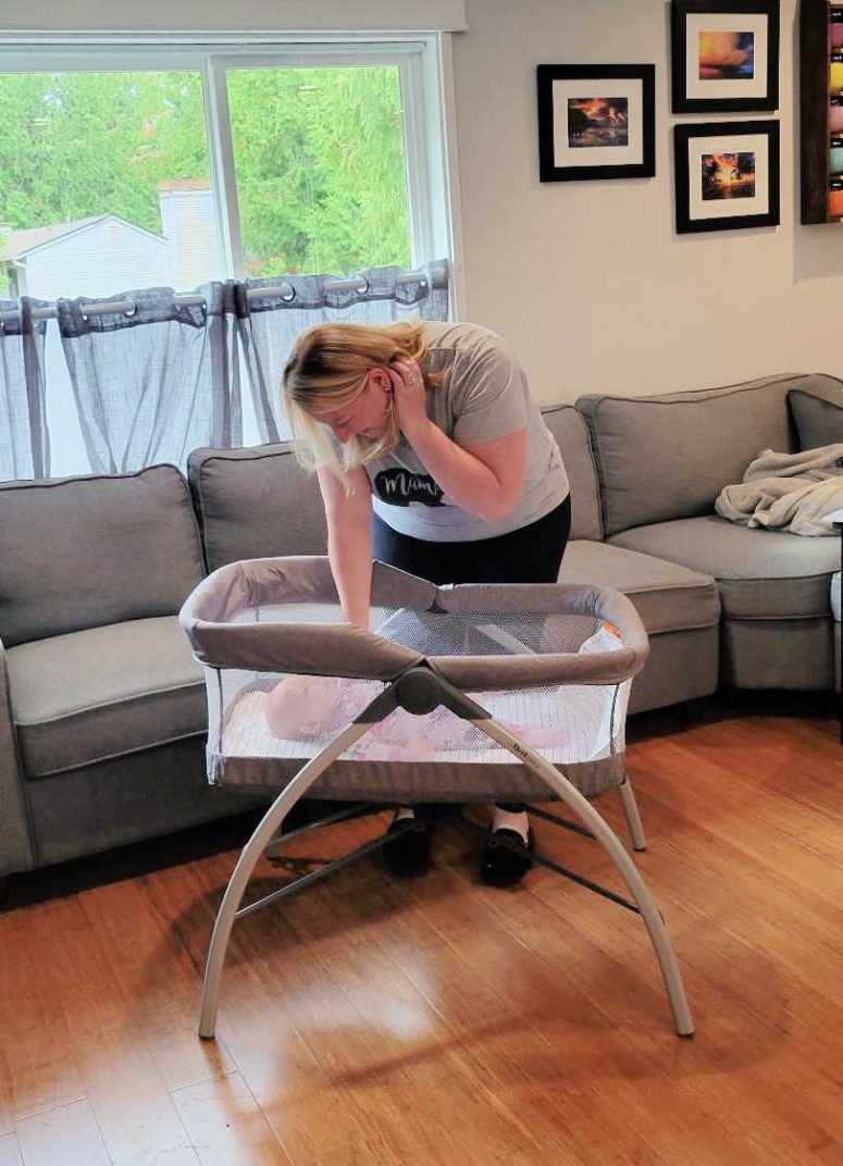 Mom putting baby into bassinet