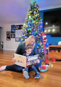Mom and Toddler reading "the nutcracker" in front of a Christmas tree