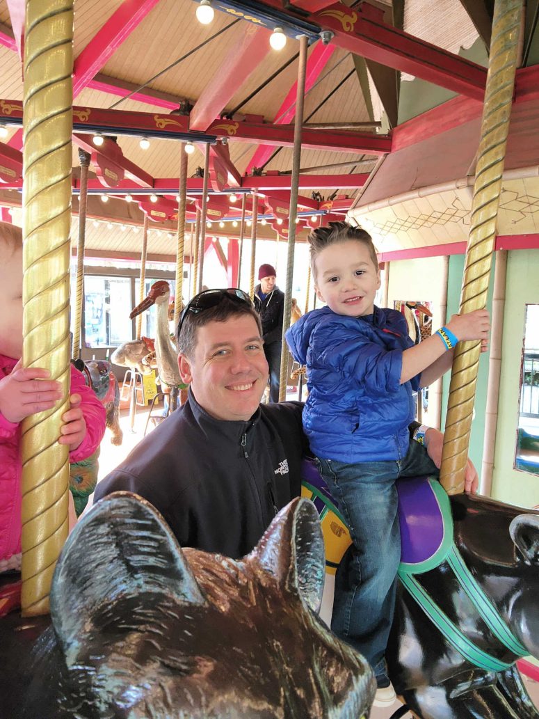 A dad and son on the carousel a the Atlanta Zoo